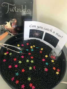 a bowl filled with black beans and stars next to a sign that says can you catch a star?