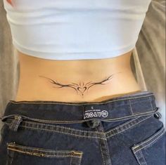 a woman's stomach with a bird tattoo on her lower back and the word love written