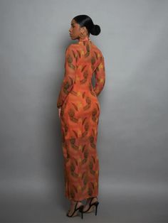 A stunning graphic print against a bold orange tulle will elicit compliments aplenty. The long-sleeve, full-length, mock turtleneck elements make this a perfect trans-seasonal option that can be worn with heels or biker boots.- Tulle, keyhole fastening at back, pearl buttons- Made in Turkey, ships from Ghana Fitted Orange Long Sleeve Maxi Dress, Orange Fitted Long Sleeve Maxi Dress, Elegant Orange Printed Maxi Dress, Orange Printed Maxi Dress For Party, Fitted Orange Maxi Dress For Fall, Elegant Orange Long Sleeve Maxi Dress, Elegant Long Sleeve Orange Maxi Dress, Orange Long Sleeve Printed Maxi Dress, Chic Orange Long Sleeve Maxi Dress