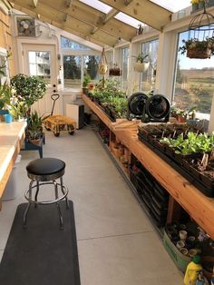 an indoor greenhouse with lots of plants and potted plants on the shelves in it