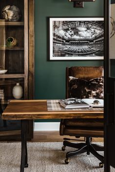 a wooden desk sitting in front of a green wall