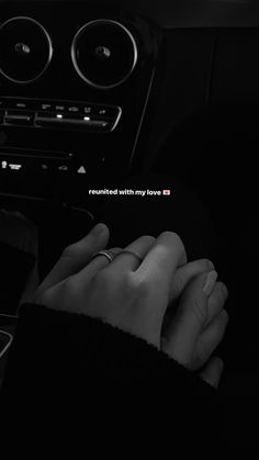 two hands holding each other in the middle of a car with an inscription on it