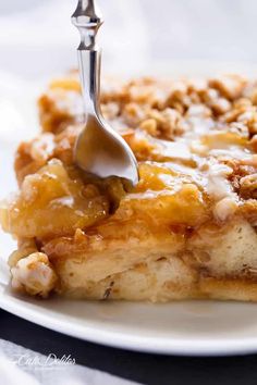 a piece of cake on a white plate with a fork in it and caramel topping