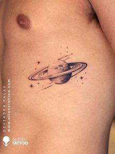 a saturn tattoo on the side of a woman's stomach with stars around it