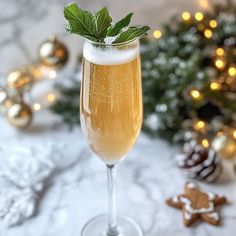 a glass filled with champagne next to a christmas tree