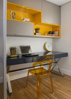 a desk with a laptop computer on top of it and a yellow chair in front of it