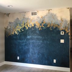 an empty room with blue and gold paint on the wall