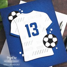 a card with a soccer jersey on it and a pen sitting next to the card