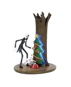 a figurine is standing next to a christmas tree