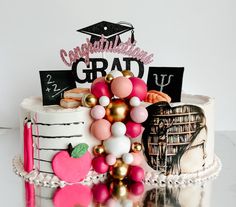 a graduation cake decorated with balloons and decorations