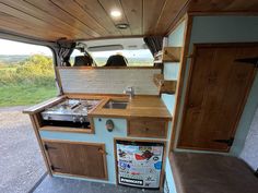 a kitchen area in an rv with wood paneling on the walls and cabinets,