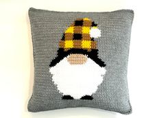 a crocheted pillow with an image of a penguin wearing a knitted hat