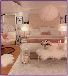 a bedroom decorated in white and pink with feathers on the bed, chandelier