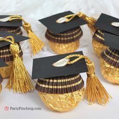 graduation hats and tassels are on top of cupcakes in gold foil