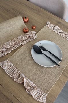 a place setting on a wooden table with silverware and napkins