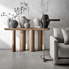 three vases are sitting on a table in front of a couch and coffee table