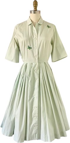 1950s fit-and-flare shirt-dress. Mint green with two green embroidered butterflies on the front. Features pleats at the waist of the skirt. Buttons up at the front.Label is Sue Brett ('A Sue Brett Junior Dress'). No fabric information, but it seems like a cotton. A slight "worn" look in some areas, but in over-all very good-excellent vintage condition!No size on tag. Fit size XS-S best.Measurements (laid flat and doubled)Bust: up to 38"Waist: 22"Hips: Open sizeLength: 41" Classic Green Cotton Dress, Green Collared Cotton Dress, Green Cotton Collared Dress, Junior Dress, Embroidered Butterflies, Embroidered Shirt Dress, Flare Shirt, Dress Mint, Embroidered Butterfly