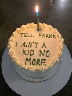 a birthday cake with a lit candle that says tell frank i ain't a kid no more