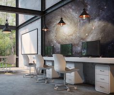 an office with multiple desks and chairs in front of a space themed wallpaper