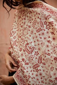 a woman wearing a red and white patterned shawl