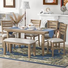 a dining room table and chairs in front of a fireplace