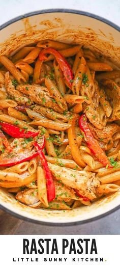 pasta with red peppers and parsley in a white pan on a table next to the words rasta pasta