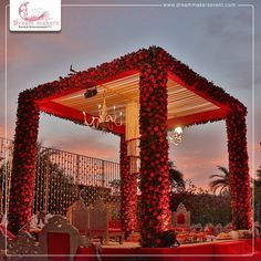 an outdoor wedding setup with red flowers on it