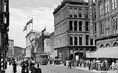 an old black and white photo of people on the street