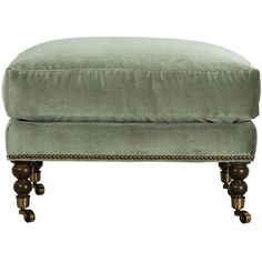 the foot stool is made from wood and has a light green velvet upholstered