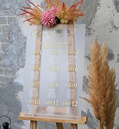 a wedding seating chart with flowers on an easel