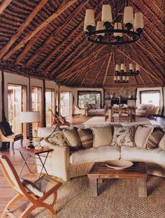 a living room filled with lots of furniture and a large wooden ceiling mounted to the side of a wall