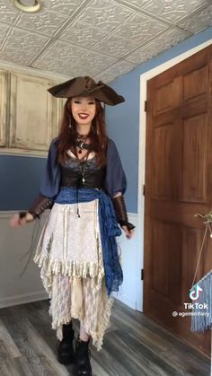 a woman dressed as a pirate standing in a room