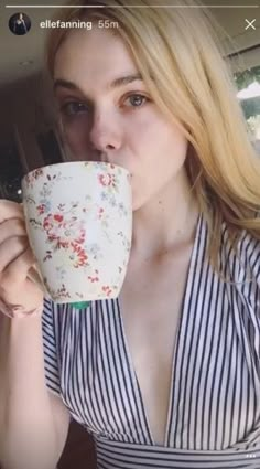 a woman drinking out of a coffee cup