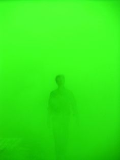 a man is standing in the fog with his back to the camera