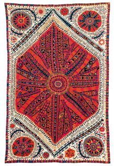 an orange, blue and red rug with intricate designs on it's edges is shown