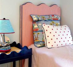 a small child's room with a bed, nightstand and lamp