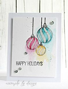 a card with three ornaments hanging from it's sides and the words happy holidays