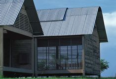 a wooden house with metal roof and shutters