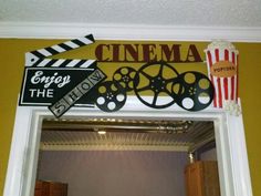 a sign that says cinema on the front of a mirror with popcorn and film reels