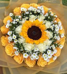 a sunflower surrounded by white and yellow flowers