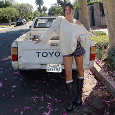 a woman standing in the back of a white truck