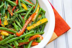 a white bowl filled with green beans and carrots