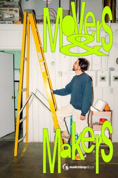 a man standing on top of a yellow ladder next to a green sign that says makers