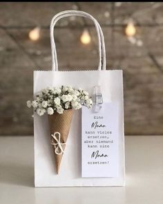 an ice cream cone with flowers in it on a white bag that says, mom