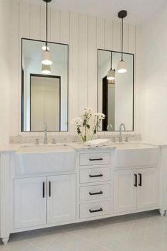 a bathroom with double sinks and two mirrors