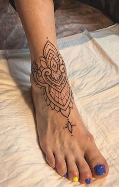 a woman's foot with a tattoo design on the top and bottom of it