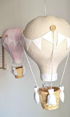 two hot air balloons in the shape of animals are suspended from strings and decorated with bows