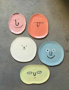 four plates with faces drawn on them sitting next to each other in front of a facebook page