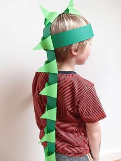 a young boy wearing a green paper crown