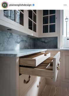 a kitchen with marble counter tops and white cabinets